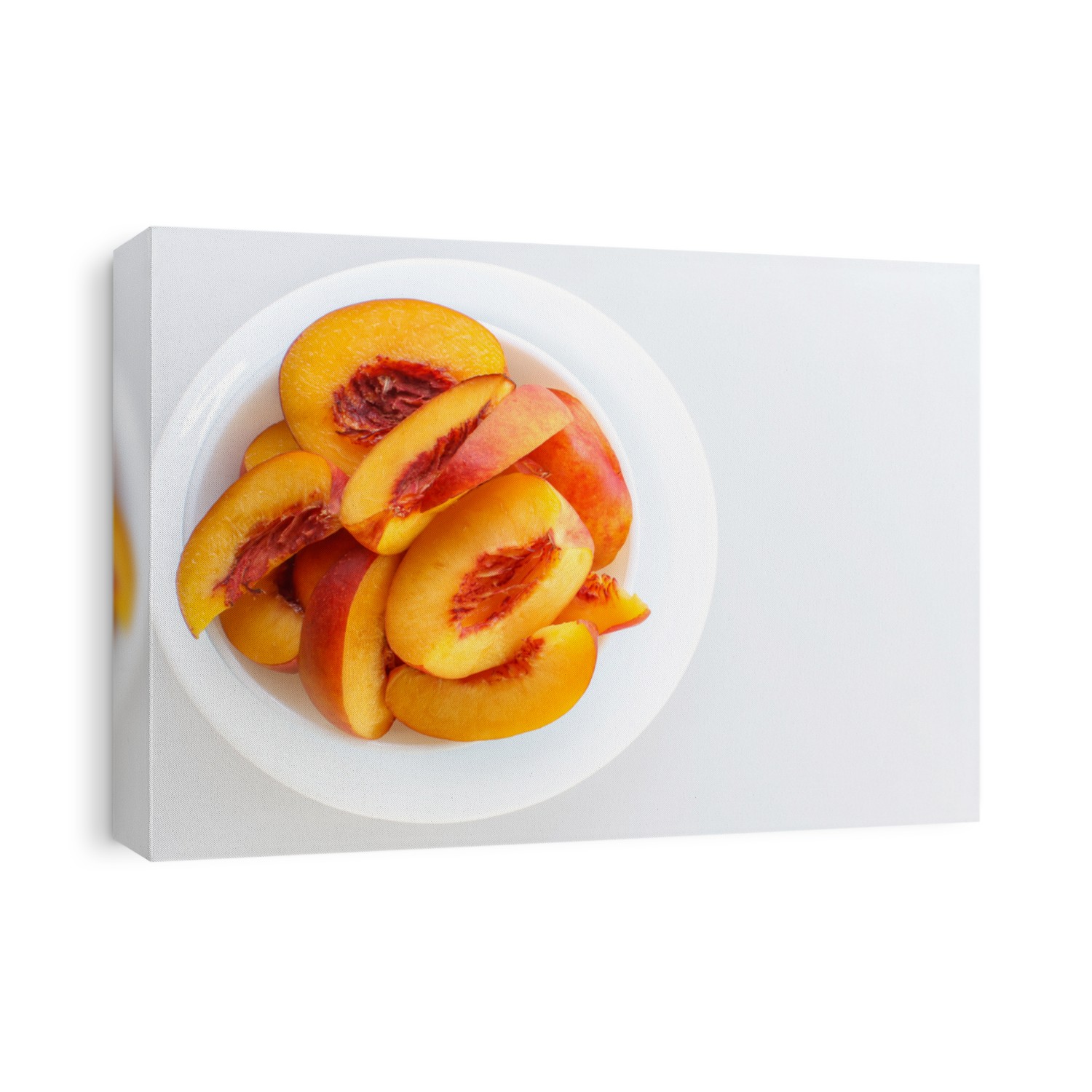 Fresh sliced peaches in white bowl, isolated